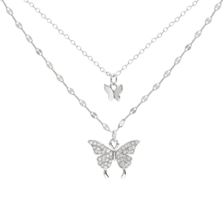 Duo-laags zilveren ketting met vlinderhanger en sprankelende zirkoniastenen, elegant en natuur-geïnspireerd sieraadontwerp.