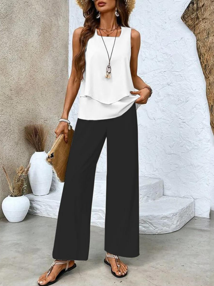 Model draagt de dames tweedelige set in een elegante styling.